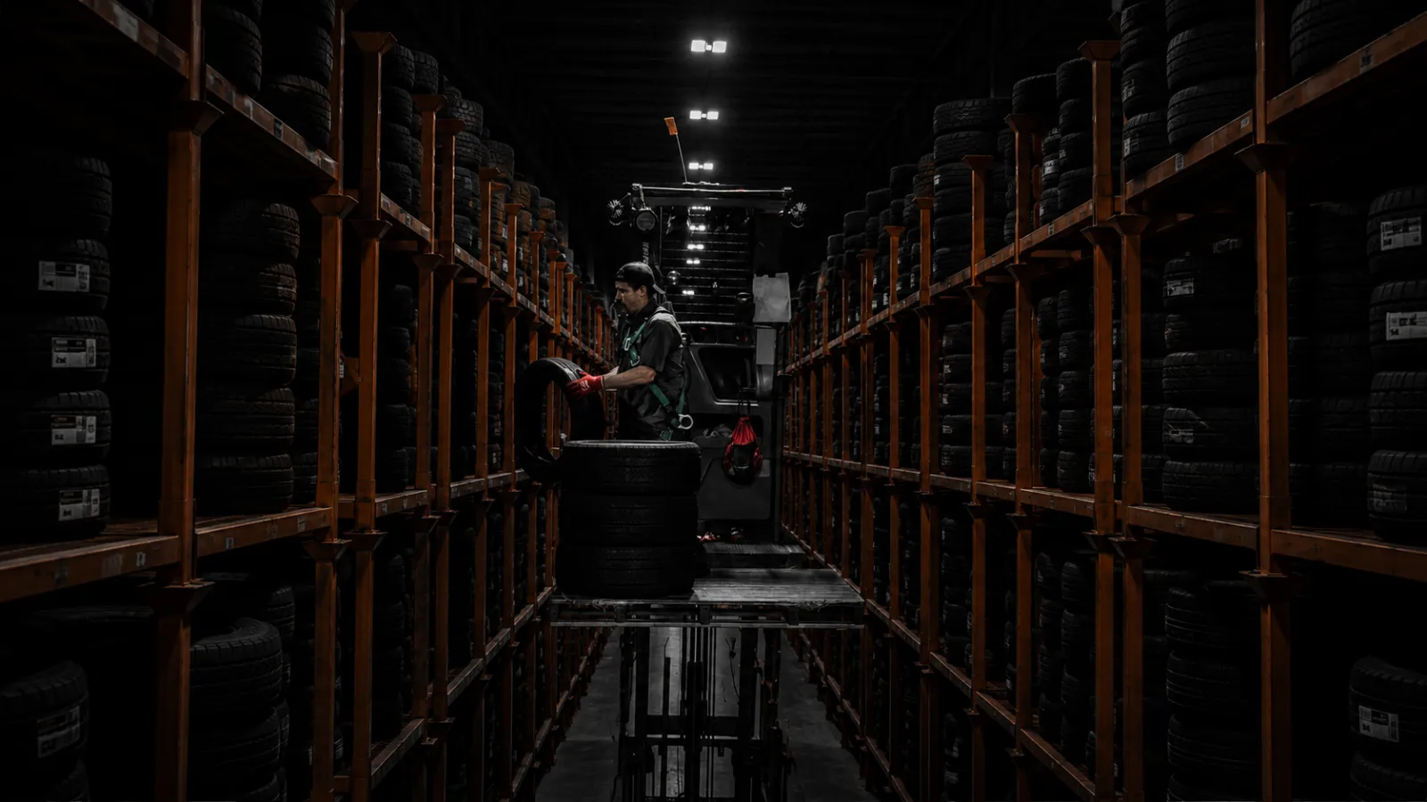 Warehouse specialist pulling tires from high-density inventory racks